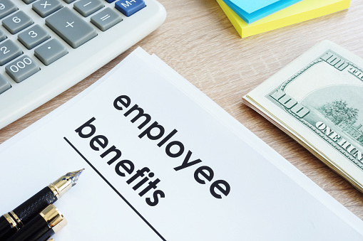 Document with title employee benefits on a desk. Document with title employee benefits on a desk.